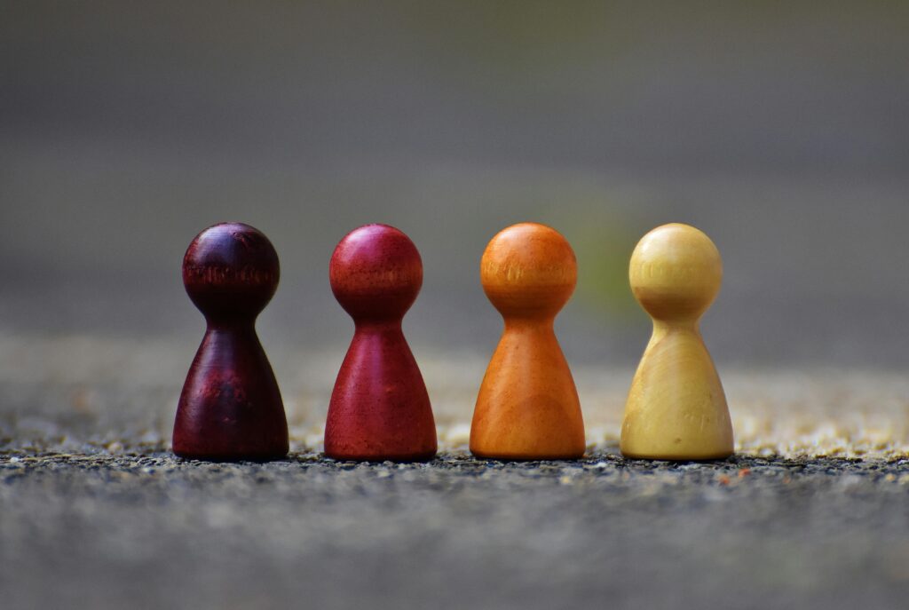 pexels-photo-209728-209728 Close-up of four colorful wooden pawn pieces arranged in a row.